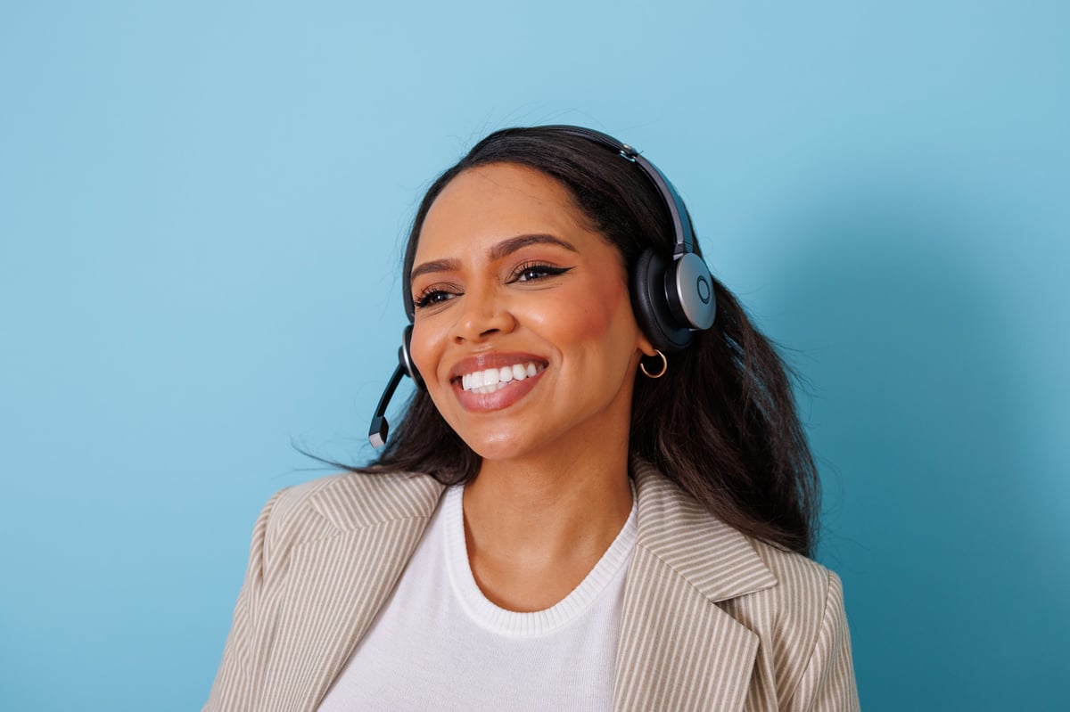 A friendly receptionist wearing a headset, speaking with a caller